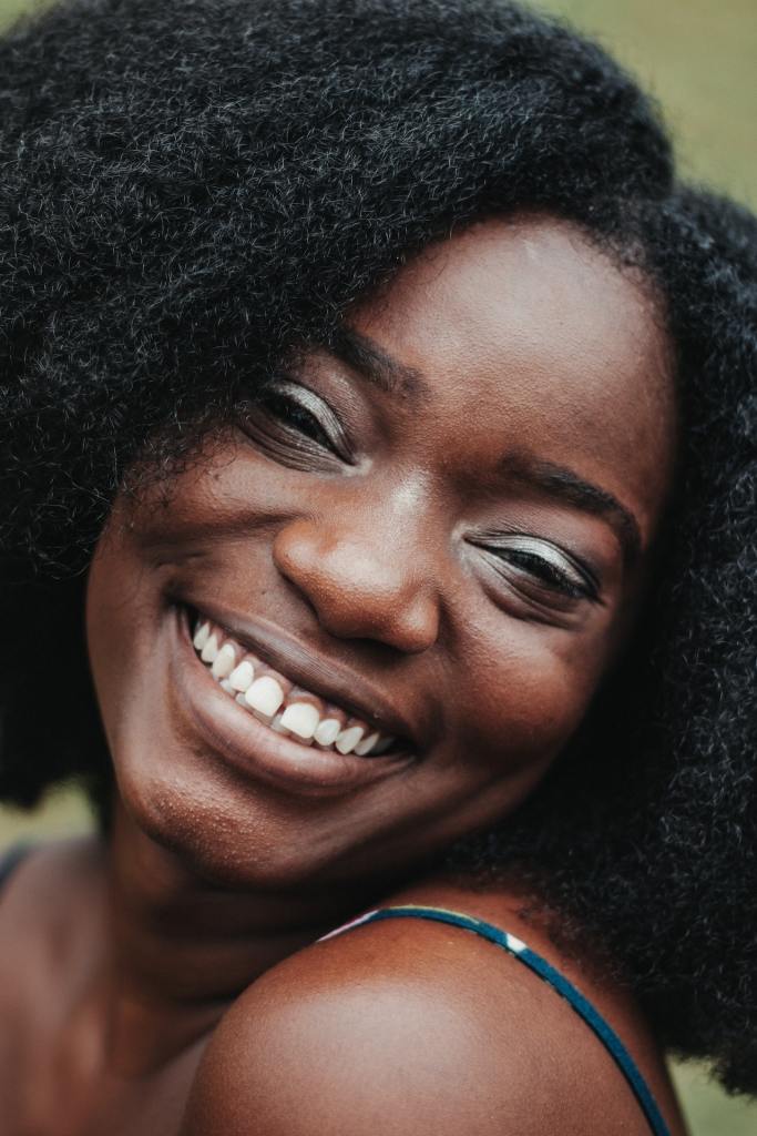 Cheerful Black woman smiling with thick, curly hair
